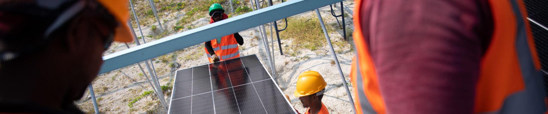 Workers carrying solar panel