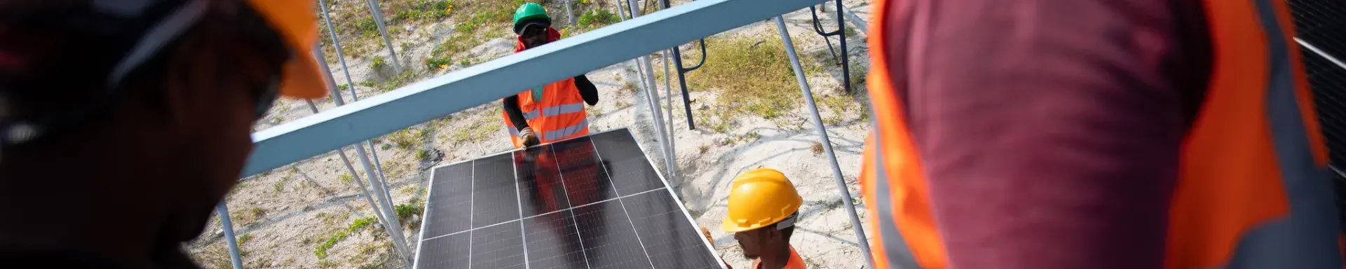 Workers carrying solar panel