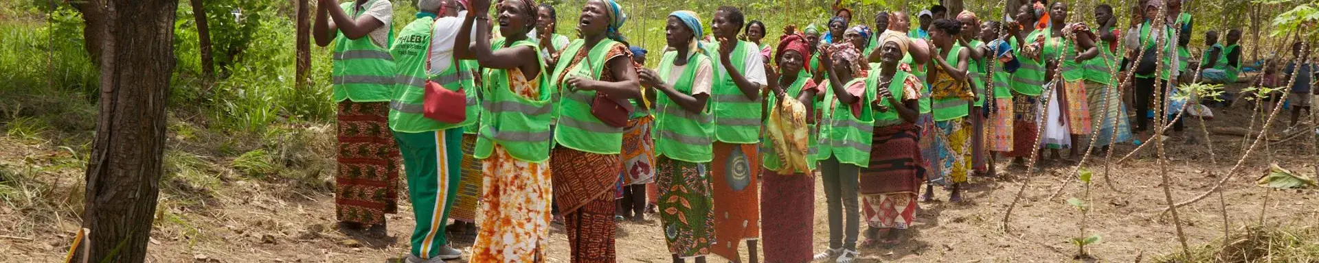 group of women standing on an untarred path within a bush