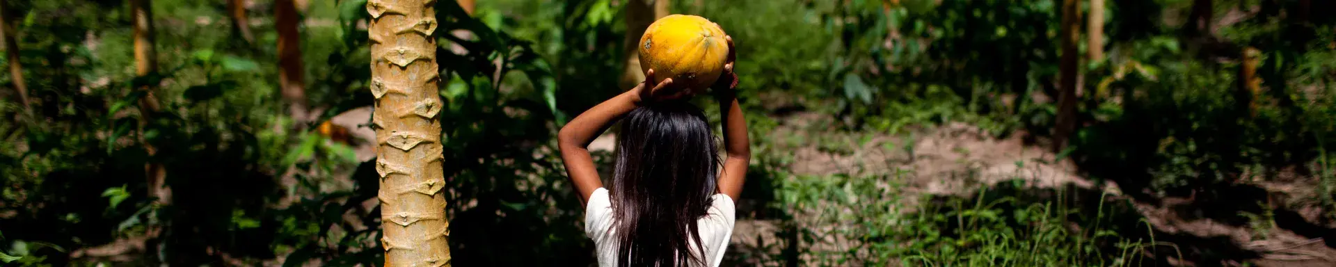 A girl with fruit on head in forest