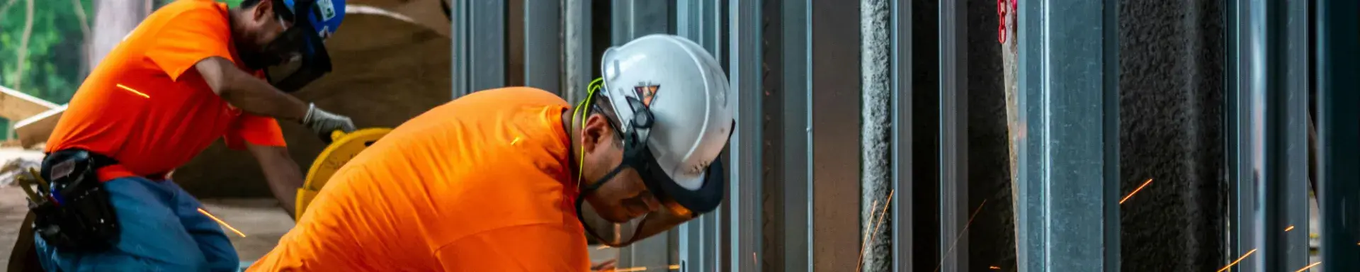 An industry worker cutting steel
