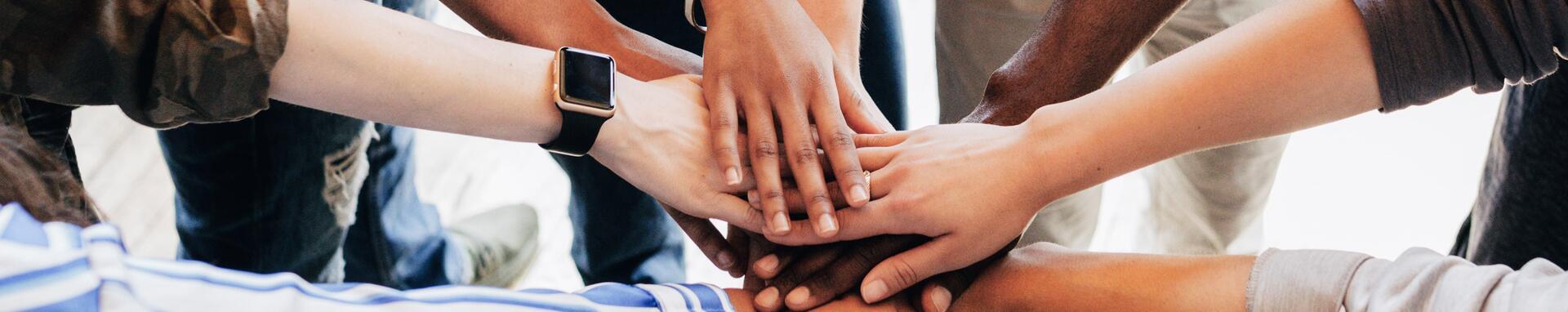 Group of diverse people stacking hands in the middle