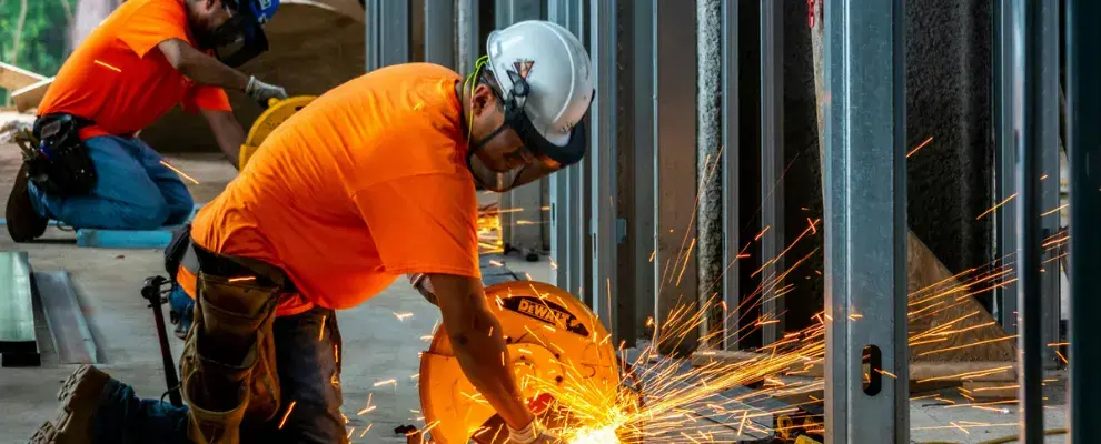 An industry worker cutting steel