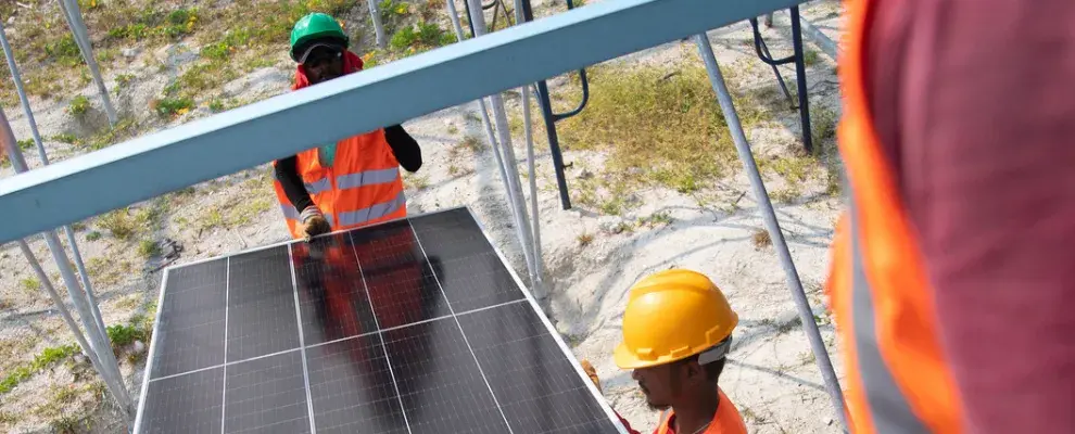 Workers carrying solar panel