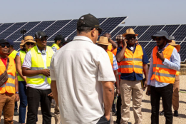 People gathered in front of solar panels