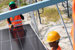 Workers carrying solar panel