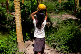 A girl with fruit on head in forest